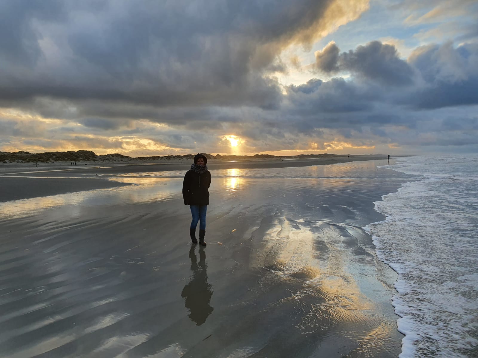 Marijke op het strand Terschelling met een indrukwekkende wolkenpartij.
